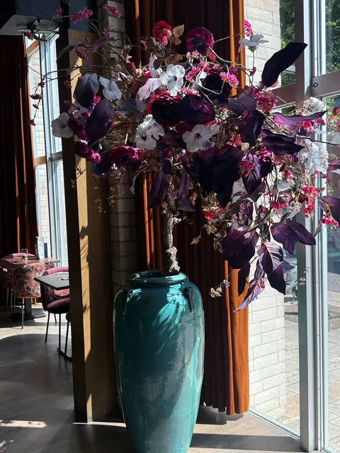 Turquoise vaas met paarse en roze zijden bloemen