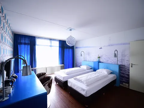 Hotelkamer van ANNO met twee eenpersoonsbedden