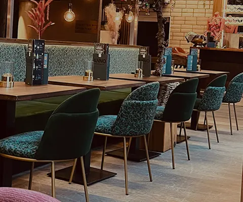 Turquoise stoelen en bakstenen muur in het restaurant van ANNO
