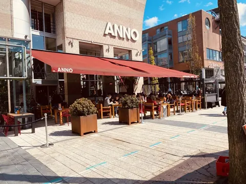 De gevel van ANNO met rode luifel aan de Grote Markt